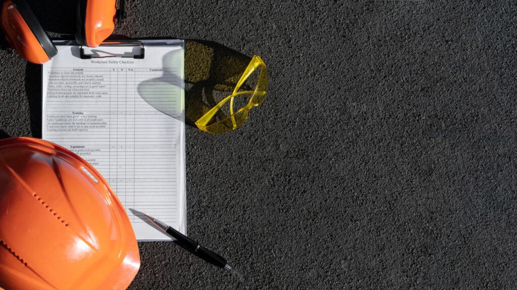 Ilustración de un engranaje con íconos de seguridad, representando un plan de seguridad ocupacional.